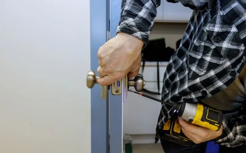 Locksmith installing a smart door lock on a home door