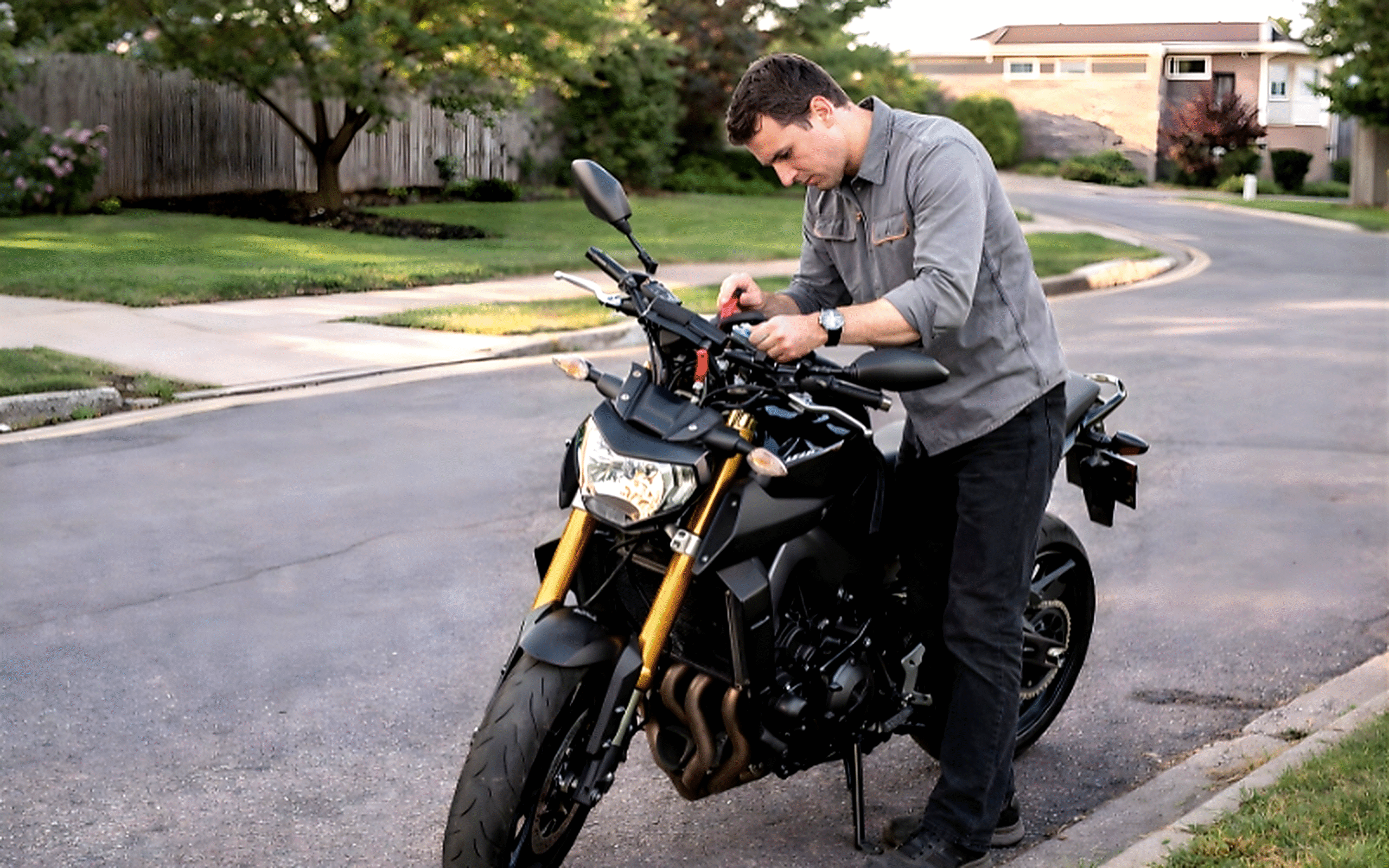 Professional motorcycle locksmith repairing bike ignition on the road during emergency service call